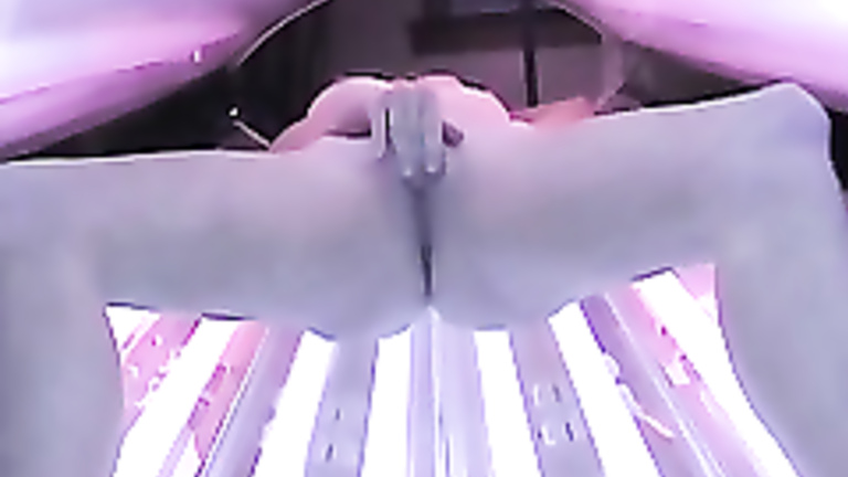 Petite blonde girl caught masturbating in the tanning bed