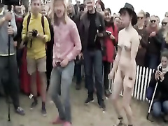 Nude man and woman learn to line dance for a crowd