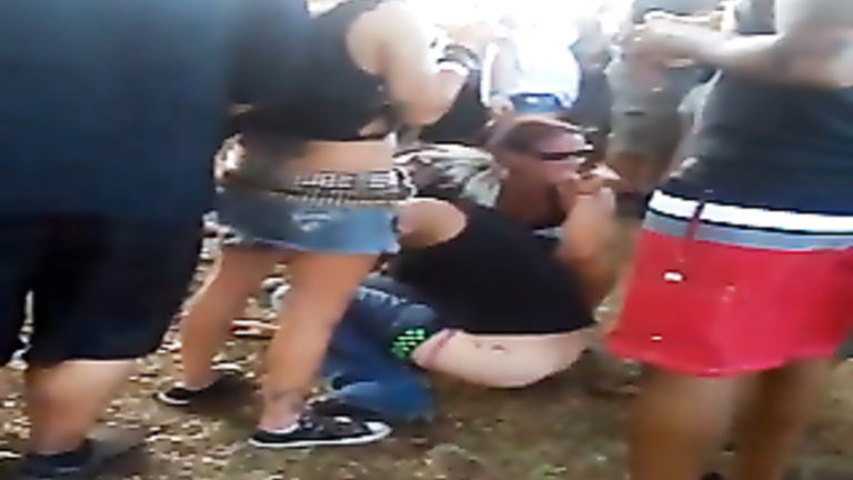 Party babe peeing in the dirt at an outdoor concert
