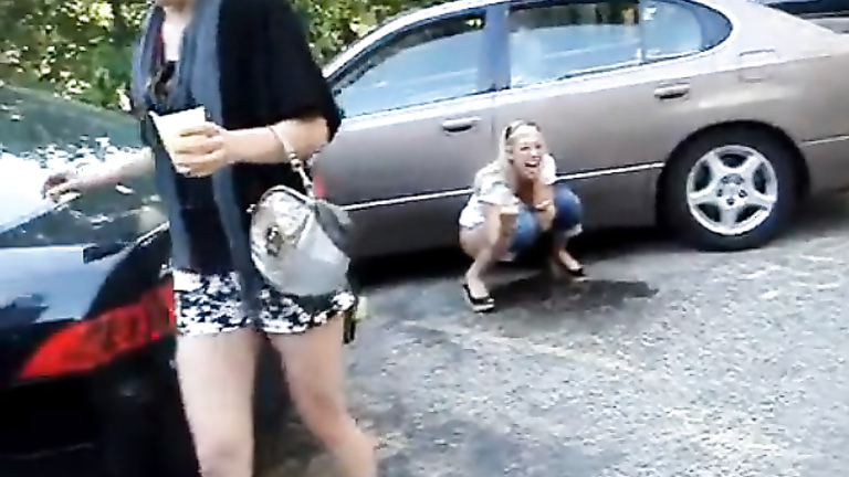 Laughing blonde girlfriend pees in the parking lot