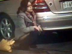 Desperate girl in glasses calmly pees on the street