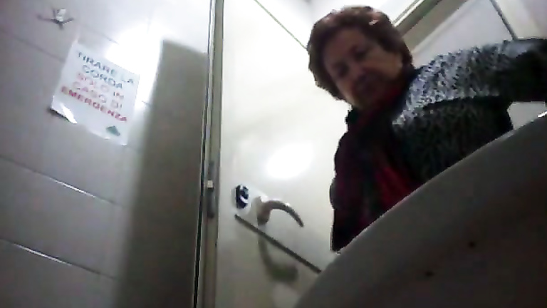 Italian mature sits on public toilet and goes pee