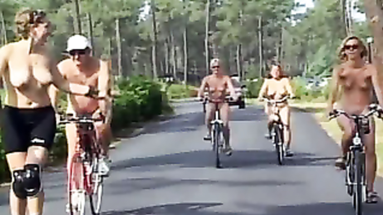 Nudist women take a bike ride to the beach