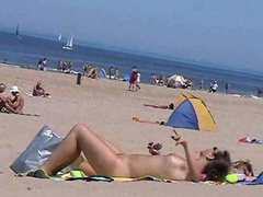Sunny day at the public beach with two nudist girls