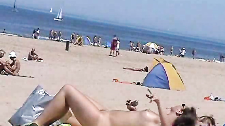 Sunny day at the public beach with two nudist girls