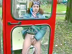 Ginger chick pisses in a phone booth in winter