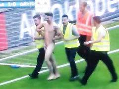 Streaking guy runs around the football pitch