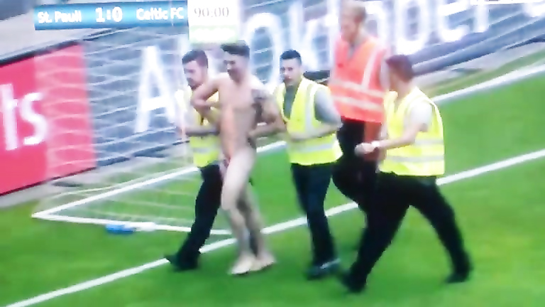 Streaking guy runs around the football pitch