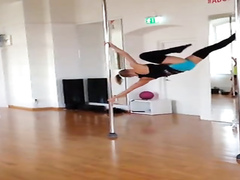 Stunningly fit girl swings around the pole