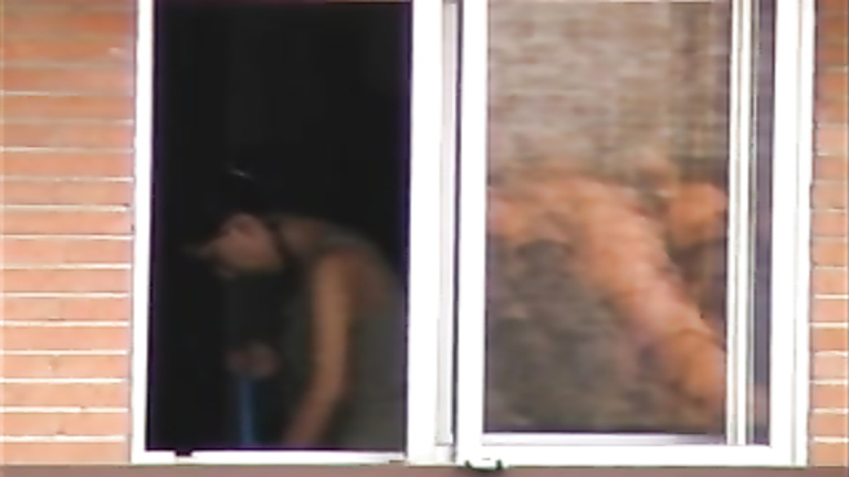 Lovely brunette neighbor changes her clothes at the window voyeurstyle