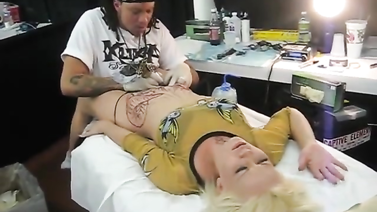 Blonde bimbo moans with pain as her pubis was being tattooed