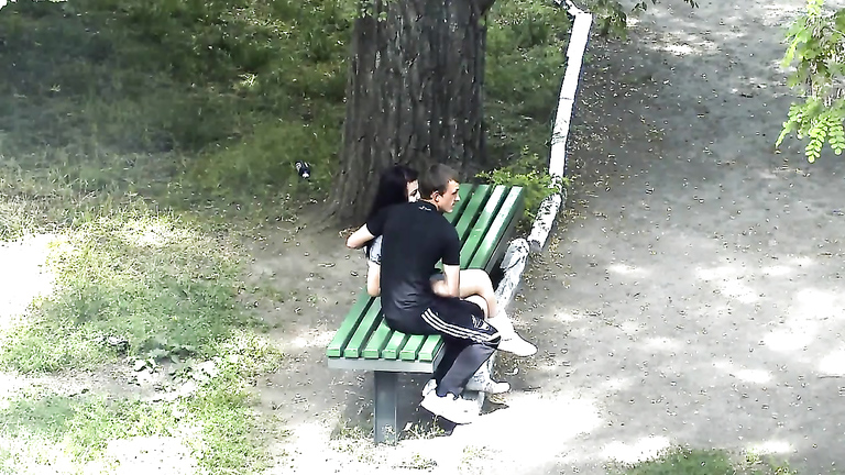 Russian lovers kiss and caress each other in the city park