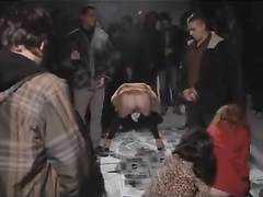 Female protesters pee on newspapers in front of other people
