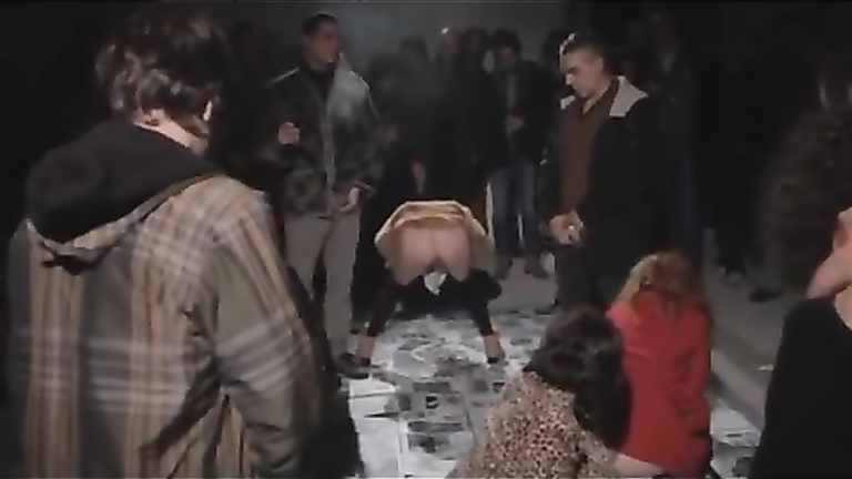 Female protesters pee on newspapers in front of other people
