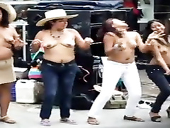 Busty Latina women dancing topless on the street