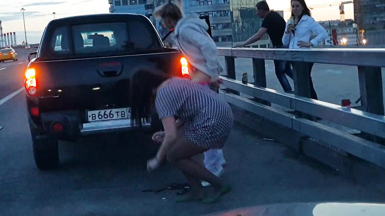 Russian chick shields her friend while she is peeing in the street