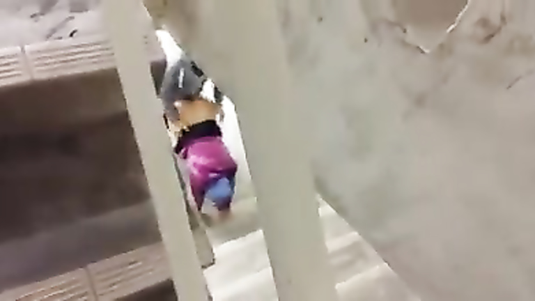 Muslim couple having some fun under the stairs