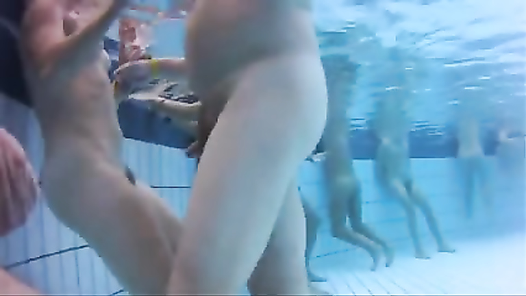 Naughty male and female nudists have some fun in the pool completely naked