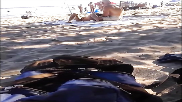 Seductive nudist girlfriend has her pussy exposed on the middle of the beach