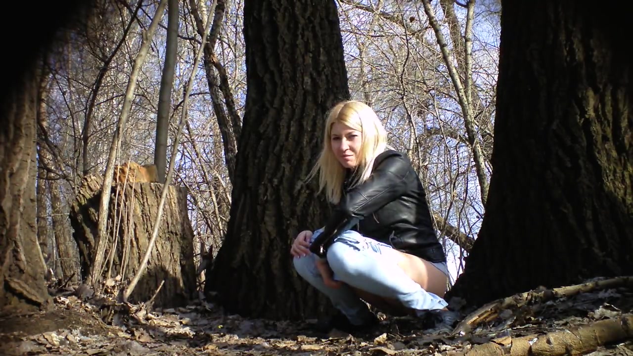 Irresistible girl holds onto jeans while piddling in the city park voyeurstyle