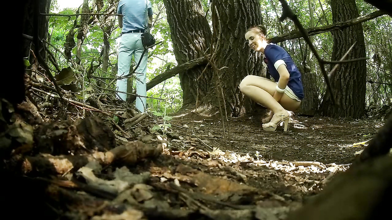 Guy stands on guard as his girlfriend pees behind a tree