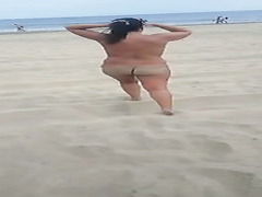 Curvaceous mature filly walks around the beach while being naked