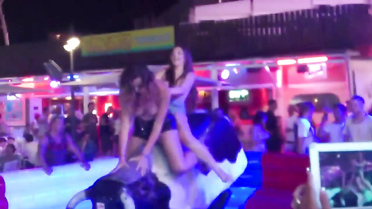 Two sexy chicks jumps on an mechanical bull while being topless