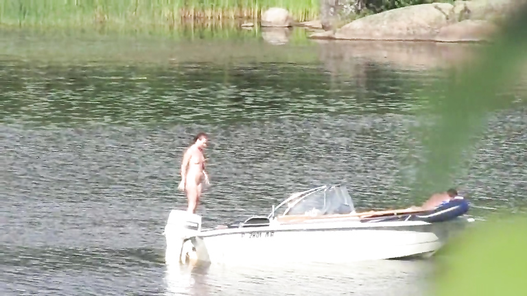 Nudist couple has fun in the middle of a beautiful lake