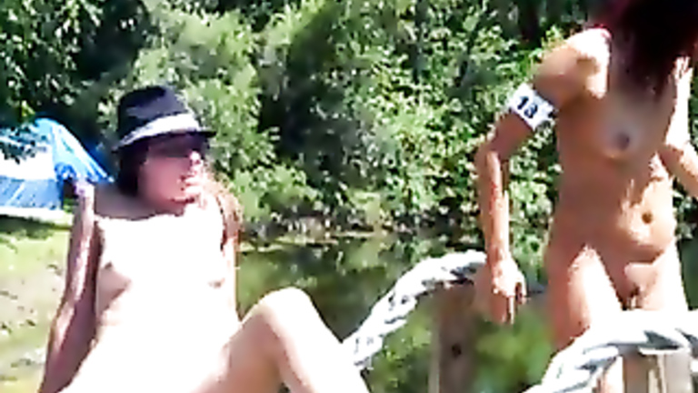 Two babes fool around at outdoor music festival