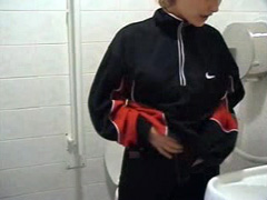 Sporty blonde pees in restroom close up