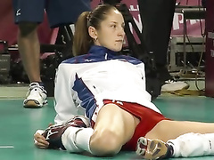 Volleyball girl in skintight shorts stretches before match