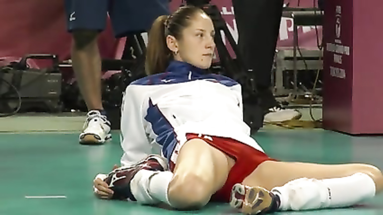 Volleyball girl in skintight shorts stretches before match