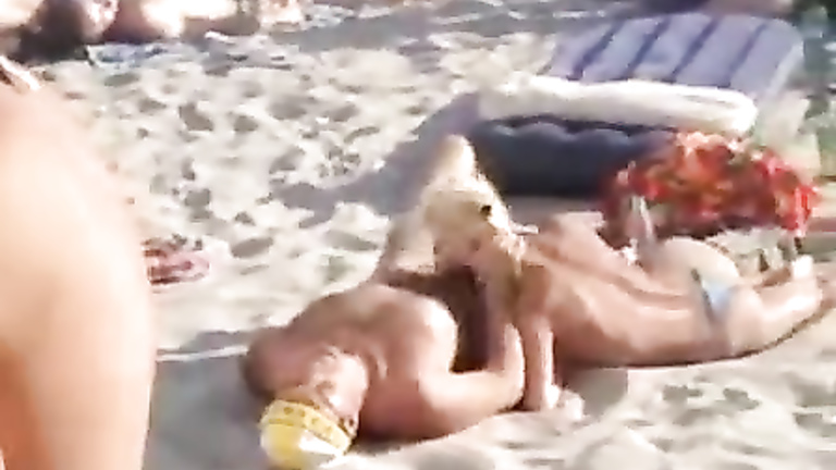 Doing the fellatio on a crowded beach