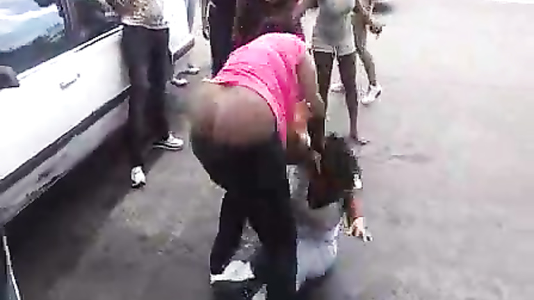 Angry black women fight in a parking lot