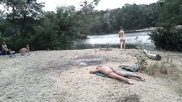 Slender nudist goes for a swim in the lake