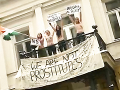 Topless protesters draw a crowd of admirers