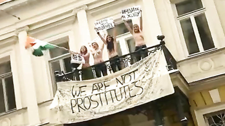 Topless protesters draw a crowd of admirers