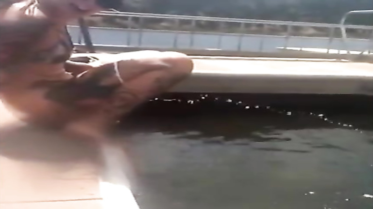 Tattooed girl takes a long piss into the lake