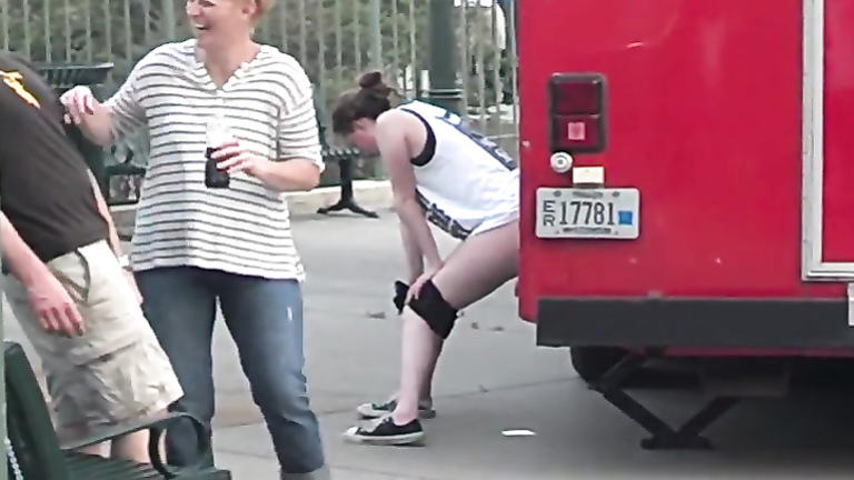 Desperate German girl takes a pee against a truck in public
