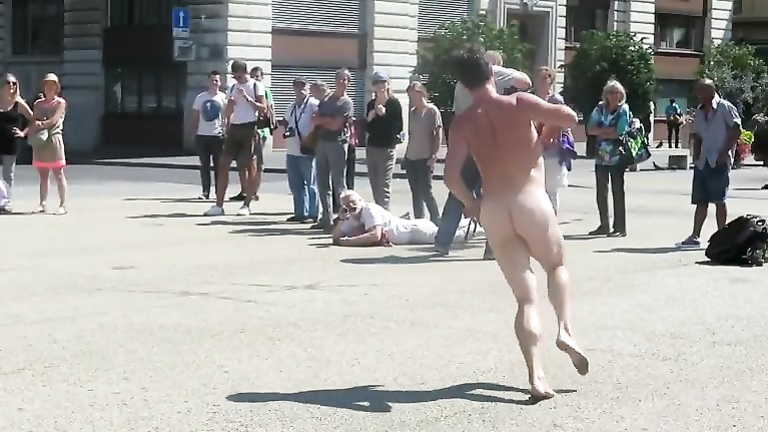 Dozens of people have gathered as the seemingly crazy naked guy runs around...